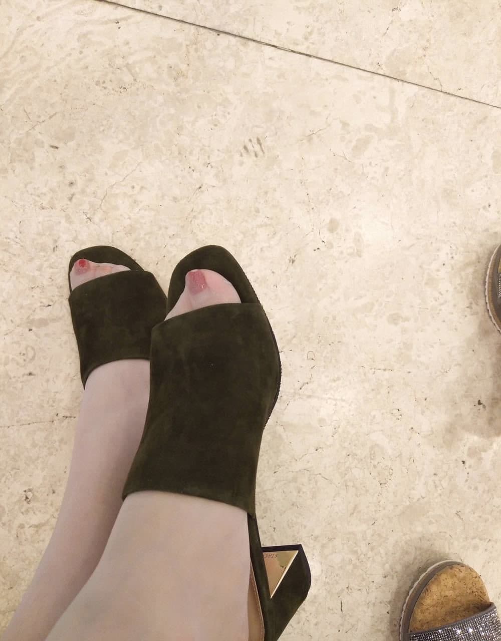 Open-toe heels showing bare toes and painted nails with soft lighting emphasizing foot curves